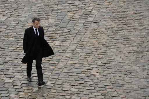 French President Emmanuel Macron walks back during a ceremony at the Invalides monument, Wednesday, Feb.7, 2024. French President Emmanuel Macron's expected political failure in decisive parliamentary elections Sunday may paralyze the country, weaken him abroad and overshadow his legacy, just as France is about to be in the global spotlight as host of the Paris Olympics. (AP Photo/Thibault Camus, File)