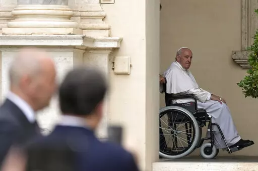 Pope Francis arrives on a wheelchair for an audience with children in the San Damaso courtyard at the Vatican, Saturday, June 4, 2022. Pope Francis added fuel to rumors about the future of his pontificate on Saturday by announcing he would visit the central Italian city of L'Aquila in August for a feast initiated by Pope Celestine V, one of the few pontiffs who resigned before Pope Benedict XVI stepped down in 2013. (AP Photo/Alessandra Tarantino, File)