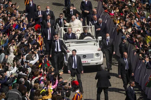Pope Francis greets the faithful as he leaves after celebrating Palm Sunday Mass in St. Peter's Square at the Vatican, Sunday, April 10, 2022. The Roman Catholic Church enters Holy Week, retracing the story of the crucifixion of Jesus and his resurrection three days later on Easter Sunday. (AP Photo/Gregorio Borgia)