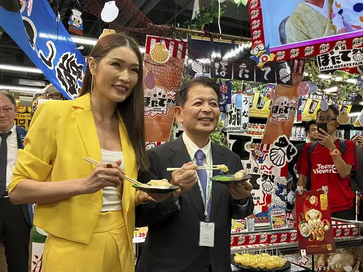 Japanese Agriculture Minister Ichiro Miyashita, right, and Malaysian celebrity Amber Chia attend an event at Japanese store, Don Don Donki in Kuala Lumpur Wednesday, Oct. 4, 2023 to promote the safety and deliciousness of Japanese scallops to shoppers. Japan hopes to resolve the issue of China's ban on its seafood within the scope of the World Trade Organization ambit and will hold food fairs overseas to bolster seafood exports amid safety concerns over the release of treated water from the Fuku