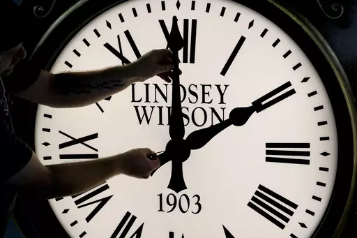 Dan LaMoore adjusts the hands on a Seth Thomas Post Clock at Electric Time Company, Oct. 23, 2020, in Medfield, Mass. Standard time comes to an end in most parts of the United States this weekend. You’ll lose an hour of sleep for one night but gain more daylight in the evening in the months ahead. (AP Photo/Elise Amendola, File)