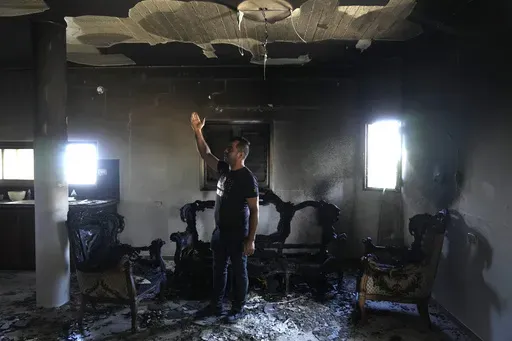 A Palestinian stands in his home the morning after it was torched in a rampage by Israeli settlers in the West Bank village of Jit, Friday, Aug. 16, 2024. (AP Photo/Nasser Nasser)