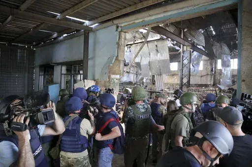Journalists visit the destroyed barracks at the Russian-controlled Olenivka prison holding Ukrainian POWs in eastern Ukraine, on Aug. 10, 2022. Russia blamed Ukraine at the time but interviews with survivors witnesses and families of the missing as well as an internal U.N. analysis pointed to Russia as the culprit two years later. (AP Photo/File)