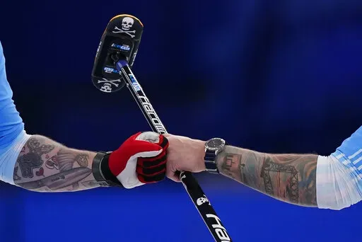 United States' Matt Hamilton, left, and Christopher Plys celebrate after a good throw during the men's curling bronze medal match between Canada and the United States at the Beijing Winter Olympics Friday, Feb. 18, 2022, in Beijing. (AP Photo/Brynn Anderson)