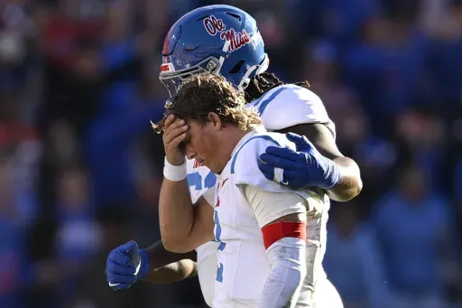 Mississippi quarterback Jaxson Dart (2) is consoled by offensive lineman Diego Pounds, rear, after throwing an interception late in the second half of an NCAA college football game against Florida, Saturday, Nov. 23, 2024, in Gainesville, Fla. (AP Photo/Phelan M. Ebenhack)