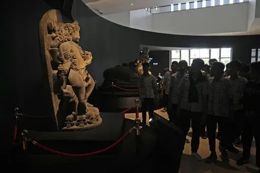 A group of students examine the statue of Hindu deity Bhairava which is a part of Indonesian historical artifacts repatriated from the Netherlands, at the National Museum in Jakarta, Indonesia, on Jan. 8, 2025. (AP Photo/Dita Alangkara)