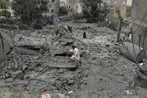 A Yemeni walks over the debris of a destroyed building following U.S. airstrikes in Sanaa, Yemen, Monday, March 24, 2025. (AP Photo)