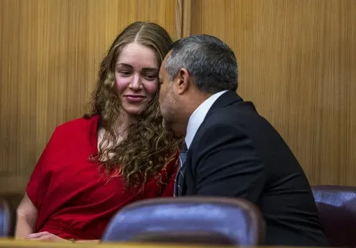 Defense attorney Frank Prieto talks with OnlyFans model Courtney Clenney in the courtroom during a hearing in front of Judge Laura Shearon Cruz, where the computer hacking charges against her and her parents, Deborah and Kim Clenney, were dismissed at the Gerstein Justice Building, Thursday, July 11, 2024, in Miami. Courtney Clenney is accused of stabbing to death her boyfriend in a Miami condo in 2022. The murder charge has not been dropped. (Pedro Portal/Miami Herald via AP)