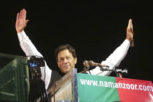 Former Pakistani Prime Minister Imran Khan waves to his supporters during an anti government rally, in Lahore, Pakistan, April 21, 2022. Pakistani police have filed terrorism charges against Khan, authorities said Monday, Aug. 22, 2022, escalating political tensions in the country as he holds mass rallies seeking to return to office. (AP Photo/K.M. Chaudary, File)