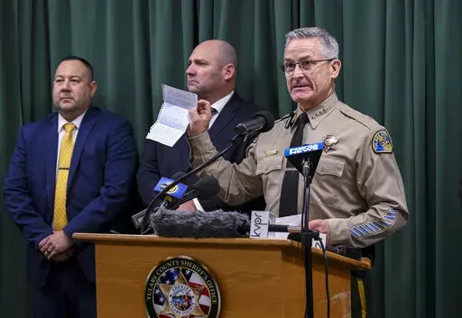Tulare County Sheriff Mike Boudreaux holds a letter Monday, Jan. 30, 2023, from a Maine woman that sent $100 to add to the reward offered for information about a mass shooting that occurred January 16, in Goshen, Calif. No arrests were announced but autopsies confirmed that all six victims died from gunshot wounds. (Ron Holman/The Times-Delta via AP)