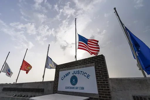 In this photo reviewed by U.S. military officials, flags fly at half-staff at Camp Justice, Aug. 29, 2021, in Guantanamo Bay Naval Base, Cuba. (AP Photo/Alex Brandon, File)