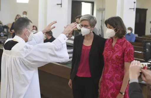 Vicar Wolfgang Rothe, left, blesses the couple Christine Walter, center, and Almut Muenster, right, during a Catholic service with the blessing of same-sex couples in St Benedict's Church in Munich, on May 9, 2021. Pope Francis has formally approved allowing priests to bless same-sex couples, with a new document released Monday Dec. 18, 2023 explaining a radical change in Vatican policy by insisting that people seeking God’s love and mercy shouldn’t be subject to “an exhaustive moral analy