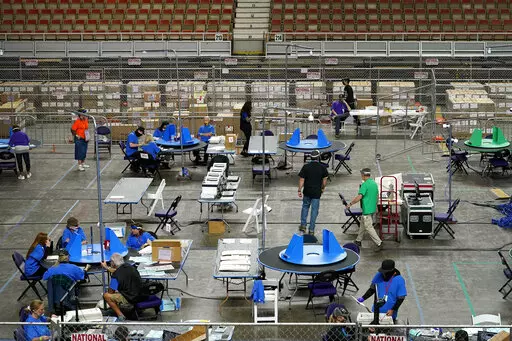 Maricopa County ballots cast in the 2020 general election are examined and recounted by contractors working for Florida-based company, Cyber Ninjas, in Phoenix on May 6, 2021. Two Republicans who control the elected board in rural Cochise County have sued their own election director to force her to conduct a greatly expanded hand count of ballots cast in the Nov. 8, 2022 election. (AP Photo/Matt York, Pool, File)