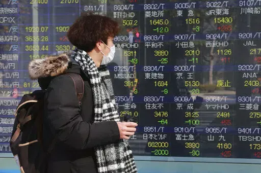 A man looks at an electronic stock board of a securities firm in Tokyo, Tuesday, Feb. 1, 2022. Asian shares gained Tuesday, mirroring broad overnight gains on Wall Street, while trading in China and most other regional markets was closed for Lunar New Year holidays. (AP Photo/Koji Sasahara)