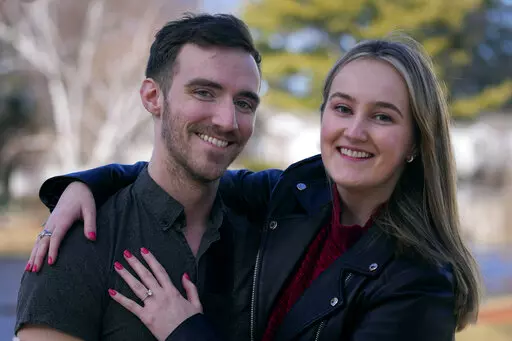 Ryan Johnson, left, poses with Anna Craven outside their home, Friday, Feb. 10, 2023, in Nashua, N.H. The recently engaged couple have also established a transparent financial relationship including being open about individual budgets and having mutual financial goals. Talking about money with your significant other might not be the most romantic topic, but it's a key element of a healthy relationship. (AP Photo/Charles Krupa)