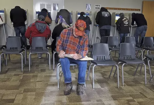 With all the voting booths filled with people, Ronald Moffit sits down to complete his ballot inside Lincoln City Hall, Nov. 8, 2016, in Lincoln, N.D. North Dakota would become the first state to require hand-counting of all election ballots if voters back a proposed ballot measure that would achieve a goal of activists across the country who distrust modern vote counting. (Tom Stromme/The Bismarck Tribune via AP, File)