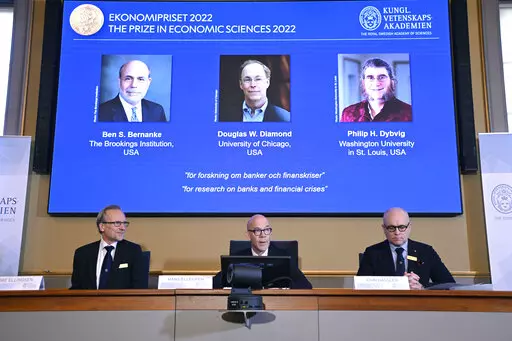 From left, Tore Ellingsen, Hans Ellegren and John Hassler members of the Royal Swedish Academy of Sciences announce the Sveriges Riksbank Prize in Economic Sciences in Memory of Alfred Nobel 2022, during a press conference at the Royal Swedish Academy of Sciences in Stockholm, Sweden, Monday, Oct. 10, 2022. From left on screen Ben S. Bernanke, Douglas W. Diamond and Philip H. Dybvig have been awarded 2022's Nobel Prize in economic sciences. (Anders Wiklund/TT News Agency via AP)