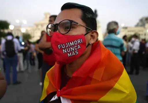 A young man wears a mask against the spread of the new coronavirus that has text that reads in Spanish "Fujimori never more," as demonstrators protest against the decision of Peru's Constitutional Court approving the release from prison of former President Alberto Fujimori in Lima, Peru, Thursday, March 17, 2022. A court official said the court restored a humanitarian pardon granted to Fujimori on Christmas Eve in 2017 by then President Pablo Kuczynski. (AP Photo/Martin Mejia)