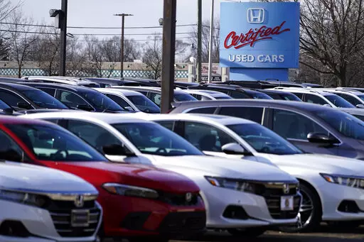 A dealership sign is seen outside of Honda certified used car dealership in Schaumburg, Ill., Thursday, Dec. 16, 2021.  Prices for used cars have soared so high, so fast, that buyers are being increasingly priced out of the market. (AP Photo/Nam Y. Huh)