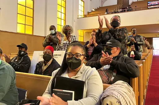 People applaud chair Kamilah Moore during a reparations task force meeting at Third Baptist Church in San Francisco, Wednesday, April 13, 2022. California's first-in-the-nation reparations task force met for the first time since its inaugural meeting nearly a year ago. The live meeting also comes mere weeks after the group voted to limit restitution to descendants of enslaved or free Black people in the U.S. before the 20th century. (AP Photo/Janie Har)