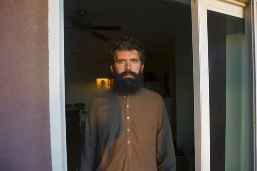 Wolayat Khan Samadzoi watches through the open balcony door of his apartment for the sliver of new moon to appear in the cloudless sky, where the sun had set beyond a desert mountain, in Las Cruces, N.M., Saturday, April 2, 2022. Samadzoi and thousands of other Afghans evacuated to the United States as the Taliban regained power last summer are celebrating their first Muslim holy month of Ramadan here – grateful to be safe, but agonizing over their families back home under the repressive Talib