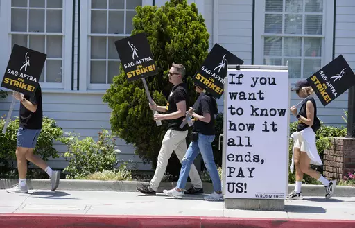 Picketers carry signs outside Amazon Studios in Culver City, Calif. on Monday, July 17, 2023. A tentative agreement between striking screenwriters and Hollywood studios offers some hope that the industry’s dual strikes may be over soon. (AP Photo/Chris Pizzello, File)