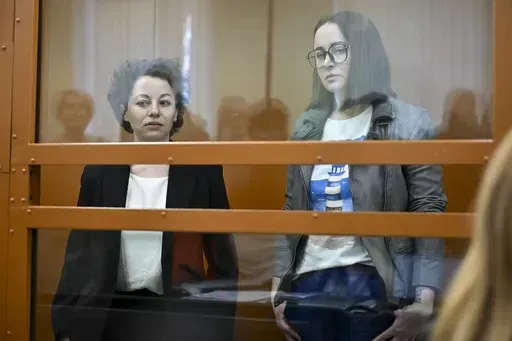 Theater director Zhenya Berkovich, left, and playwright Svetlana Petriychuk are seen in a glass cage prior to a hearing in a court in Moscow, Russia, Monday, May 20, 2024. Berkovich, a prominent independent theater director, and Petriychuk, a playwright have been behind bars since early May. Authorities claim a play they staged, "Finist, the Brave Falcon," justifies terrorism, which is a criminal offence in Russia punishable by up to seven years in prison. (AP Photo/Dmitry Serebryakov)