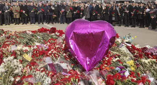 A group of ambassadors of foreign diplomatic missions attend a laying ceremony at a makeshift memorial in front of the Crocus City Hall on the western outskirts of Moscow, Russia, Saturday, March 30, 2024. (Sergei Ilnitsky/Pool Photo via AP)
