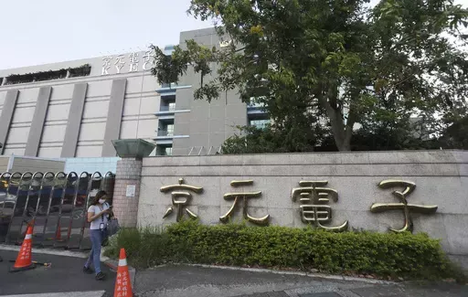 A worker walks past the logo of the factory of King Yuan Electronics Co. after work in Miaoli County, western Taiwan, May 9, 2024. In late April 2024, King Yuan Electronics Corp., a Taiwanese company specializing in semiconductor testing and packaging, said it was ending its two-decade-long run in mainland China by selling off its entire stake, worth $670 million, in its venture in the eastern Chinese city of Suzhou. (AP Photo/Chiang Ying-ying)