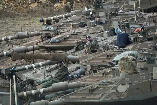 Israeli soldiers work on tanks in a staging area in northern Israel near the Israel-Lebanon border, on Oct. 1, 2024. (AP Photo/Baz Ratner, File)