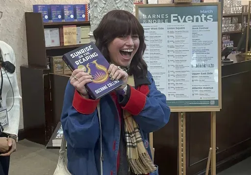 Ella Dolynchuk holds her copy of "Sunrise on the Reaping" by Suzanne Collins at a midnight launch party at Barnes & Noble bookstore in New York on Tuesday, March 18, 2025. (AP Photo/Hillel Italie)