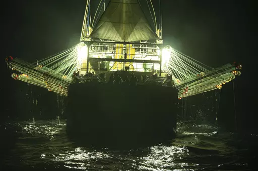 In this July 2021 photo provided by Sea Shepherd, the Chang Tai 802, a Chinese-flagged ship, fishes for squid at night on the high seas off the west coast of South America. Hazardous work conditions sometimes akin to slavery have been detected on nearly 500 industrial fishing vessels around the world, including this one, but identifying those responsible for abuses at sea is hampered by a lack of transparency and regulatory oversight, according to research by the Financial Transparency Coalition