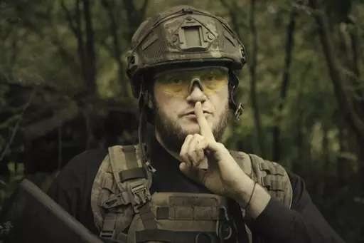In this image made from video provided by Ukrainian Defense Ministry on Sunday, June 4, 2023, a Ukrainian soldier poses for the camera with his fingers to his lips, in an undisclosed location in Ukraine. A video released by the Ukrainian Defense Ministry on Sunday shows its military gesturing to silence suggesting that no formal announcement of a possible counter offensive against Russia will be made. The on-screen text of the video reads "Plans love silence. There will be no announcement of the