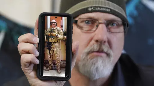 Matthew Butler, who spent 27 years in the Army, holds a 2014 photograph of himself during his last deployment in Kabul Afghanistan, on Wednesday, March 30, 2022, in Sandy, Utah. Butler is now one of the military veterans in several U.S. states who are helping convince conservative lawmakers to take cautious steps toward allowing the therapeutic use of hallucinogenic mushrooms and other psychedelic drugs. The therapeutic used of so-called magic mushrooms and other psychedelic drugs is making inro