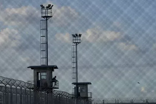 A prison guard sits in a watchtower at the Pinero jail in Pinero, Argentina, Tuesday, April 9, 2024. President Javier Milei has called for harsher penalties against drug traffickers and military intervention. (AP Photo/Natacha Pisarenko)