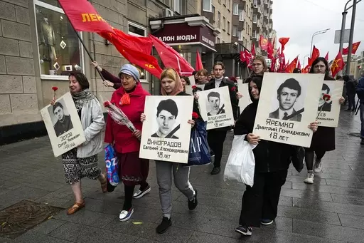 People march with flowers and portraits of those who were killed during the 1993 bloody clashes between government forces and supporters of the rebellious parliament during a rally marking the 30th anniversary of the events in Moscow, Russia, Wednesday, Oct. 4, 2023. The authorities said that 124 people died in the clashes on Oct. 3-4, 1993, but unofficial estimates suggested a higher death toll. (AP Photo/Alexander Zemlianichenko)