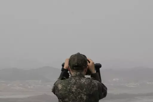 A South Korean army soldier watches the North Korea side from the Unification Observation Post in Paju, South Korea, near the border with North Korea, Friday, March 24, 2023. North Korea said Friday its cruise missile launches this week were part of nuclear attack simulations that also involved a detonation by a purported underwater drone as leader Kim Jong Un vowed to make his rivals "plunge into despair." (AP Photo/Ahn Young-joon)