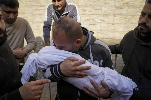 A Palestinian man holds the body of his 11 month-old nephew Mohammad Shaban, killed in an Israeli army airstrikes at the Al-Ahli Hospital in Gaza City, Tuesday, March 18, 2025. (AP Photo/Abdel Kareem Hana)