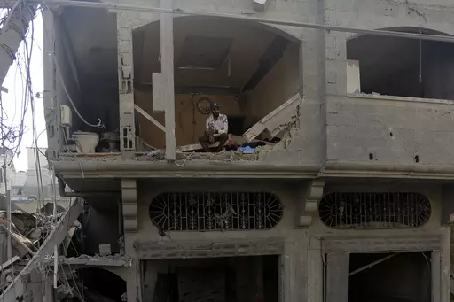 A Palestinian man watches as others inspect the damage to destroyed houses after Israeli airstrikes on Gaza City, Tuesday, Oct. 24, 2023. Hundreds of thousands of Palestinians have decided to stay in their homes in northern Gaza despite Israeli warnings that they are facing grave danger if they don't move to an evacuation zone in the southern part of the territory. (AP Photo/Abed Khaled, File)