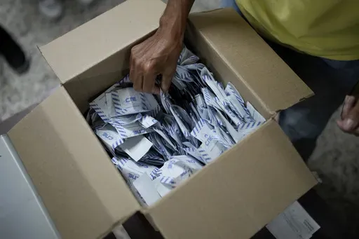 Electoral officials tally votes after polls closed for presidential elections in Caracas, Venezuela, Sunday, July 28, 2024. (AP Photo/Matias Delacroix)
