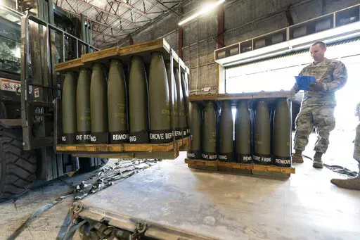 U.S. Air Force Staff Sgt. Cody Brown, right, with the 436th Aerial Port Squadron, checks pallets of 155 mm shells ultimately bound for Ukraine, April 29, 2022, at Dover Air Force Base, Del. U.S. officials say that as Russia’s war on Ukraine drags on, U.S. security assistance is shifting to a longer-term campaign that will likely keep more American military troops in Europe into the future. They say a new aid package to be announced includes an additional roughly $3 billion to train and equip U
