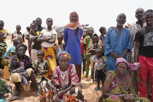 Internally displaced people wait for aid in Djibo, Burkina Faso, May 26, 2022, when violence linked to al-Qaida and the Islamic State group began surging and spreading across the West African nation. (AP Photo/Sam Mednick, File)