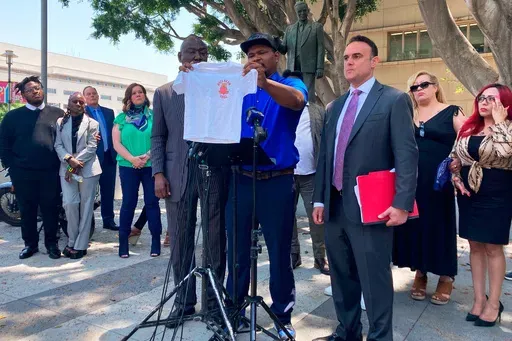 Jonathan Wright, 39, holds up the T-shirt he was given when he first went to MacLaren Children's Center in El Monte as an 8-year-old during a news conference in Los Angeles, June 9, 2022. (AP Photo/Christopher Weber, File)