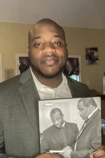 Darrell Dixon holds a photo of him and his dad, Darrell Dixon Sr., at his home in Hernando, Miss., on August 11, 2024. (Millicent Dixon via AP)
