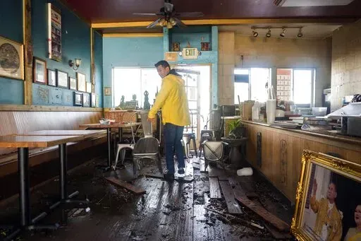 Dominic King, owner of My Thai Beach, surveys storm damage that destroyed his restaurant in Capitola, Calif., Thursday, Jan. 5, 2023. Damaging hurricane-force winds, surging surf and heavy rains from a powerful “atmospheric river” pounded California on Thursday, knocking out power to tens of thousands, causing flooding, and contributing to the deaths of at least two people, including a child whose home was hit by a falling tree. (AP Photo/Nic Coury)