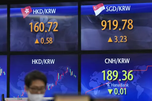 A currency trader stands near the screens showing the foreign exchange rates at a foreign exchange dealing room in Seoul, South Korea, Wednesday, May 25, 2022. Asian stock markets were mixed Wednesday after Wall Street sank on weak U.S. housing sales and a profit warning by a prominent social media brand. (AP Photo/Lee Jin-man)