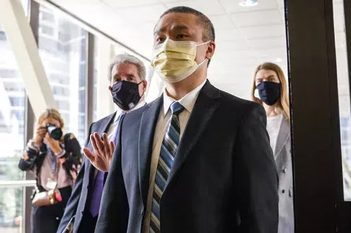 Former Minneapolis Police Officer Tou Thao enters the Hennepin County Courthouse with his attorneys before a motions hearing in Minneapolis on July 21, 2020. Thao, who is charged with violating George Floyd's civil rights when the Black man was killed under fellow Officer Derek Chauvin's knee took the stand in federal court Tuesday, Feb. 15, 2022, testifying about academy training that included handcuffing drills in which knees were used to restrain people. (Evan Frost/Minnesota Public Radio via