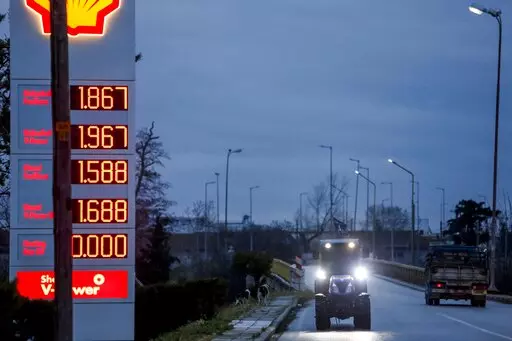 Farmer Dimitris Kakalis, 25, driving his tractor, approaches a gas station, in Tyrnavos town, central Greece, Sunday, Feb. 13, 2022. Economists, farmers and charity workers agree about a cost-of-living crisis in Europe: Inflation may ease later this year but the impact of the spike in food and energy prices will last. (AP Photo/Giannis Papanikos)