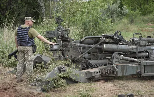 A Ukrainian soldier stands at a U.S.-supplied M777 howitzer in Ukraine's eastern Donetsk region Saturday, June 18, 2022.  (AP Photo/Efrem Lukatsky)