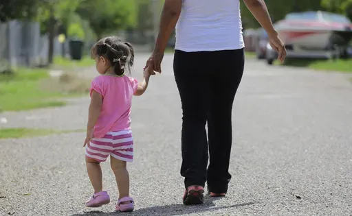 In this Sept. 16, 2015, photo, a woman in Sullivan City, Texas, who said she entered the country illegally, walks with her daughter who was born in the United States, but was denied a birth certificate. (AP Photo/Eric Gay, File)